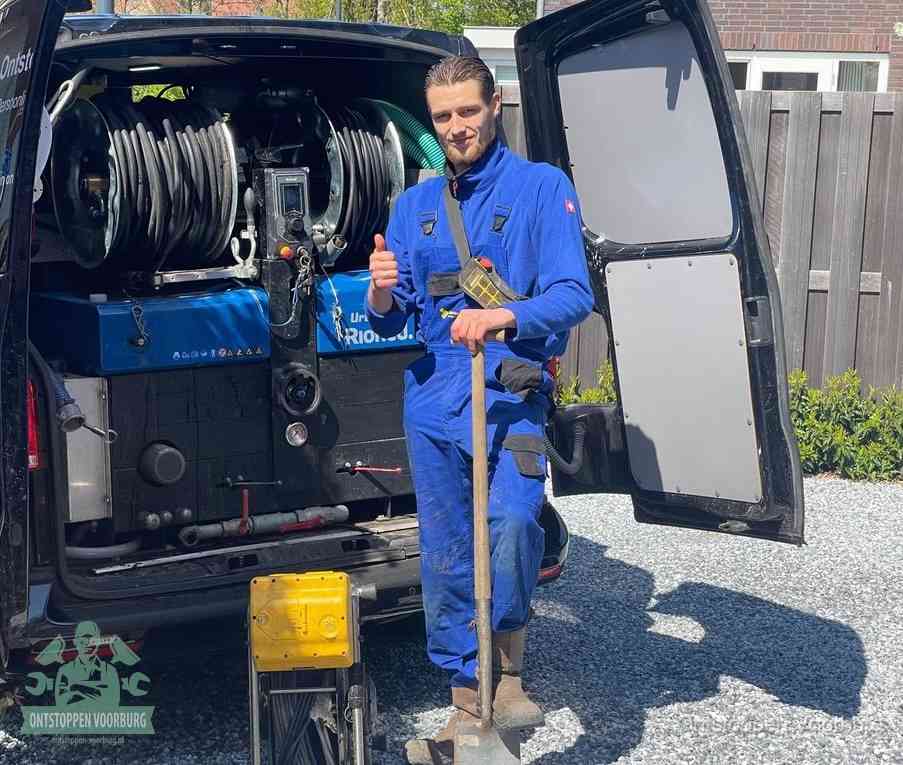 Een tevreden monteur met opgestoken duim naast de bestelbus, slim en snel ingrijpen bespaart geld bij een verstopping in Voorburg