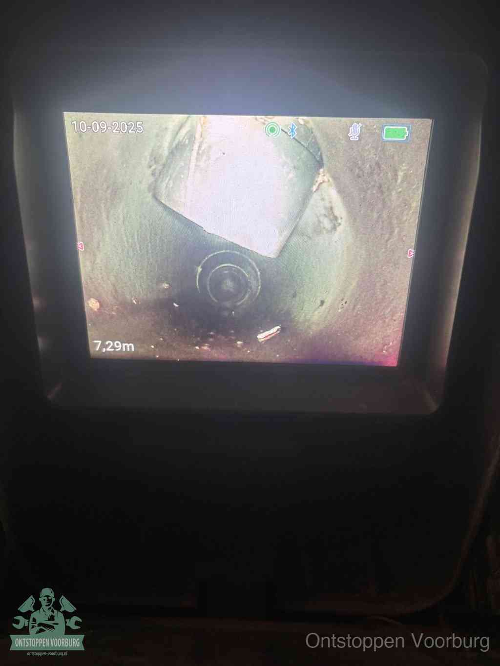 Het scherm van een rioolinspectiecamera toont de binnenkant van de leiding, eerst vaststellen waar de verstopping zit in Voorburg
