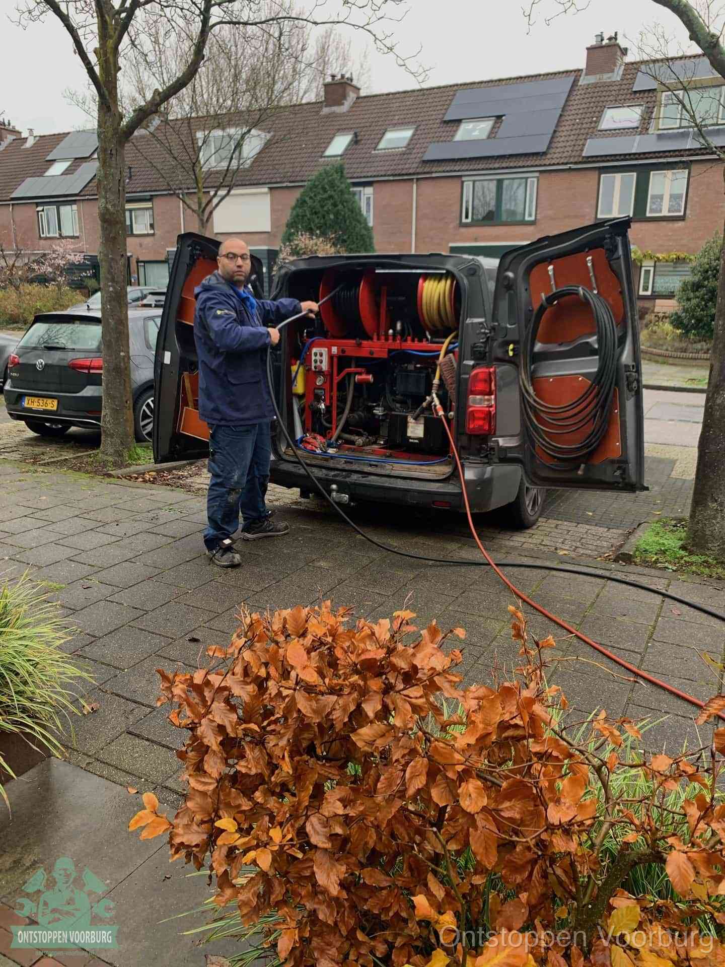 Een monteur staat bij zijn open bestelbus met hogedruk-rioolreinigingsapparatuur, klaar om binnen 30 minuten uit te rukken voor een spoedverstopping in Voorburg